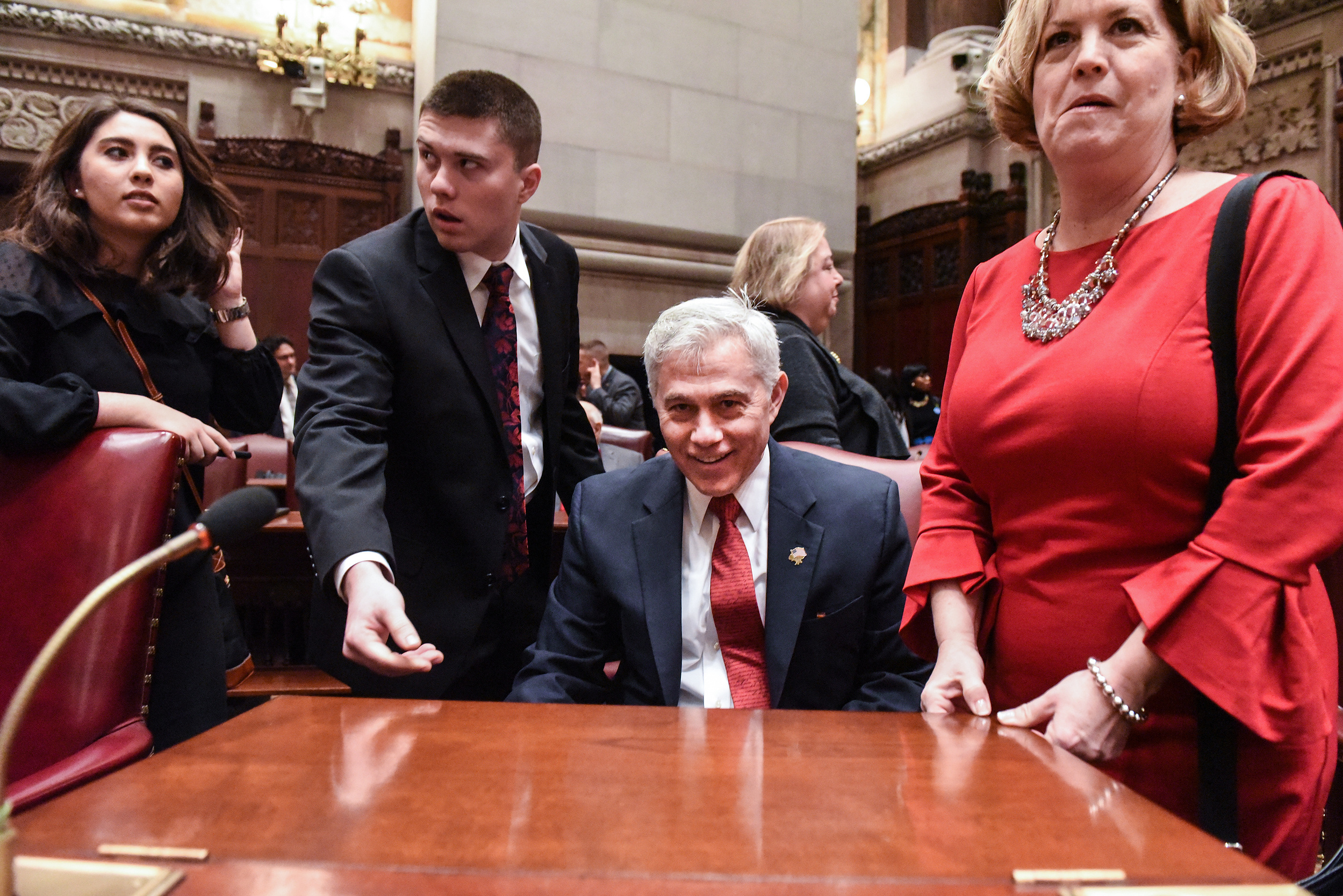 Bob Antonacci finds his seat surrounded by his family after the swearing in of the Senators in the Senate Chamber in Albany, NY, U.S., on January 9, 2019. (Stephanie Keith for The New York Times)